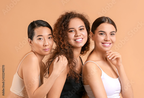 Beautiful young women with healthy skin on color background