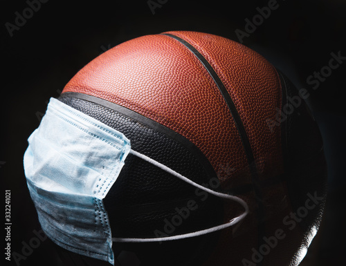 Beat the disease. Basketball player with ball in protective mask. Prevention of pneumonia respiratory symptoms such as fever, headache, cough. Chinese coronavirus. Healthcare, medicine, sport concept. photo