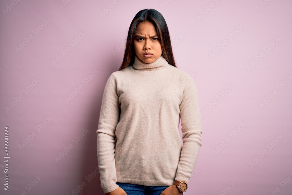 Young beautiful asian girl wearing casual turtleneck sweater over isolated pink background skeptic and nervous, frowning upset because of problem. Negative person. Young beautiful asian girl wearing casual turtleneck sweater over isolated pink background skeptic and nervous, frowning upset because of problem. Negative person.