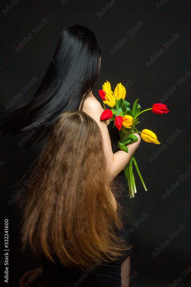 Naklejka premium Portrait of girl and woman with tulips in the Studio
