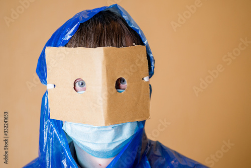 person in a home-made protective suit and medical mask in anxiety from a coronovirus pandemic photo