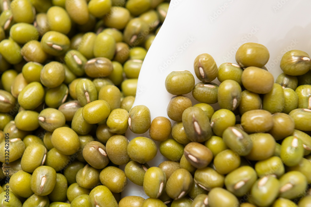 Bunch of Green Mung Beans in a White Ceramic Bowl. Macro shot. Cooking traditional dishes Bunch of Green Mung Beans in a White Ceramic Bowl. Macro shot. Cooking traditional dishes