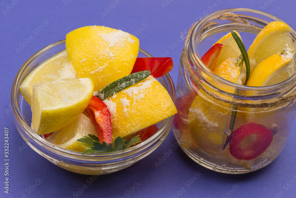 Fermented lemons with salt and chili pepper in jars.