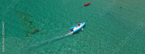Aerial drone ultra wide photo of motor boat cruising in high speed in tropical exotic bay with emerald sea