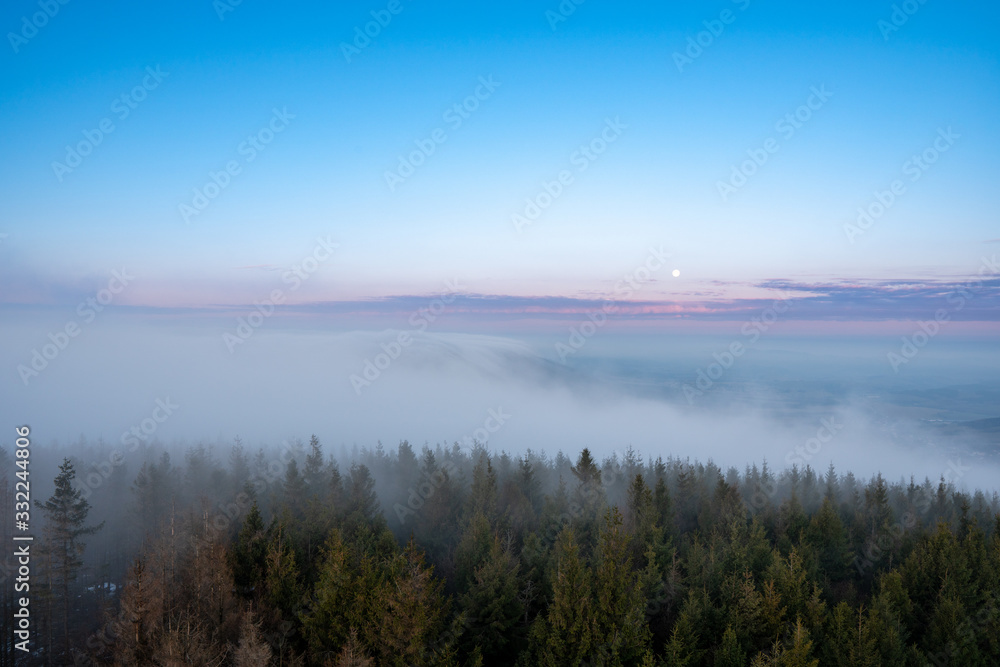 beautiful fog in mountains before sunrise with forest with moon, Czech Beskydy