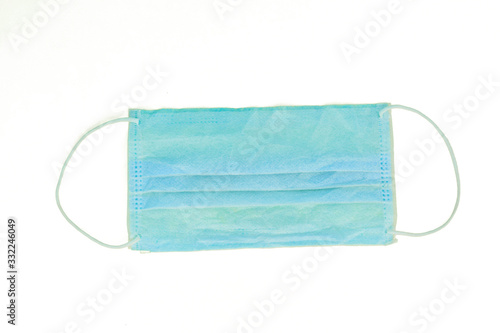 Surgical mask with white rubber straps isolated on a light white paper background