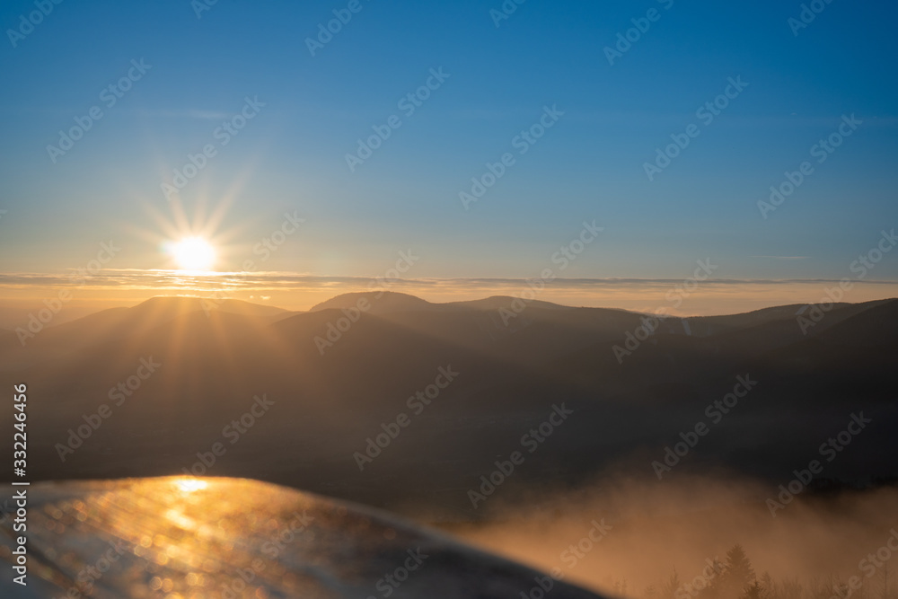 Sunrise in mountains with fog in valley with beautiful reflection of parsk on wood, Czech Beskydy