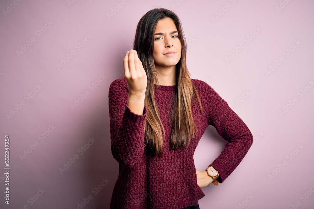 Young beautiful girl wearing casual sweater over isolated pink background Doing Italian gesture with hand and fingers confident expression Young beautiful girl wearing casual sweater over isolated pink background Doing Italian gesture with hand and fingers confident expression