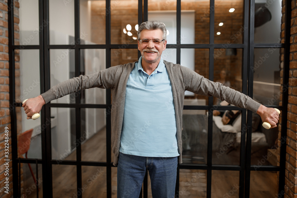 Happy senior man with dumbbell doing morning xercise Happy senior man with dumbbell doing morning xercise