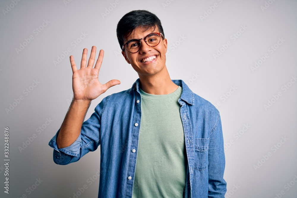 Young handsome man wearing casual shirt and glasses over isolated white background showing and pointing up with fingers number five while smiling confident and happy. Young handsome man wearing casual shirt and glasses over isolated white background showing and pointing up with fingers number five while smiling confident and happy.