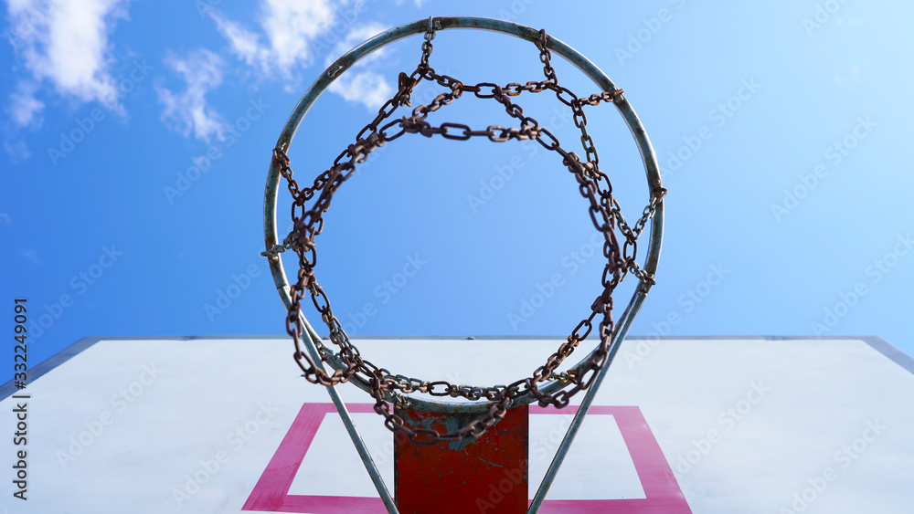 yard basketball hoop against the blue sky and white fluffy clouds. Basketball basket with chains in the open. street sport. yard basketball hoop against the blue sky and white fluffy clouds. Basketball basket with chains in the open. street sport.