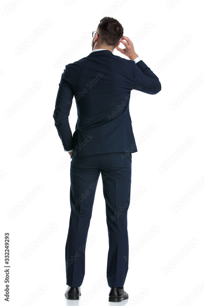 businessman standing and scratching head while pondering a decision businessman standing and scratching head while pondering a decision