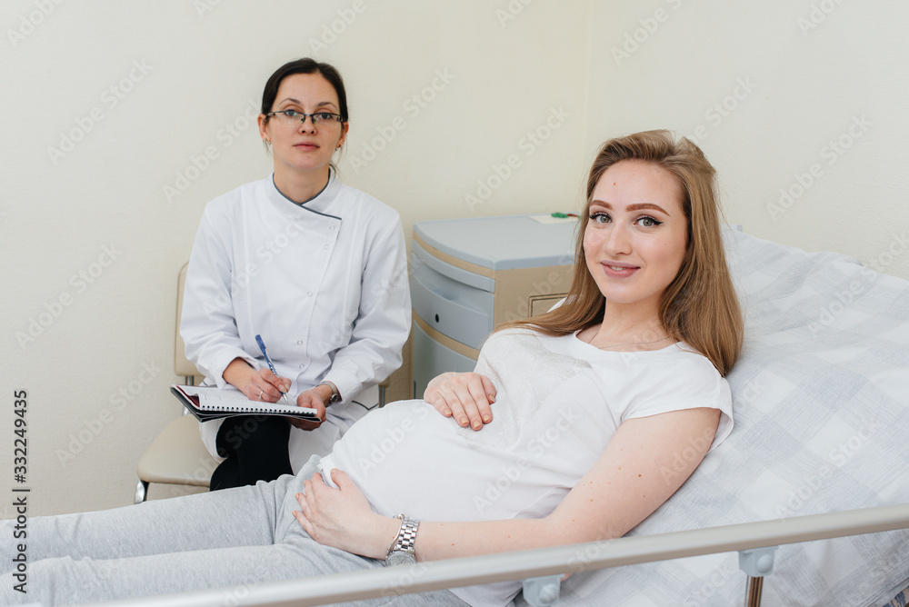 Obraz premium The doctor advises and serves a young pregnant girl in a medical clinic. Medical examination