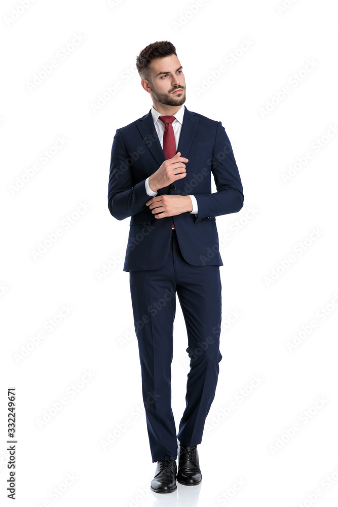 formal man walking and holding hand on sleeve's button formal man walking and holding hand on sleeve's button
