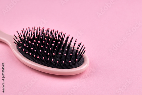 pink hairbrush isolated on a pink coral background with space. beauty hair accessory for hairstyle.