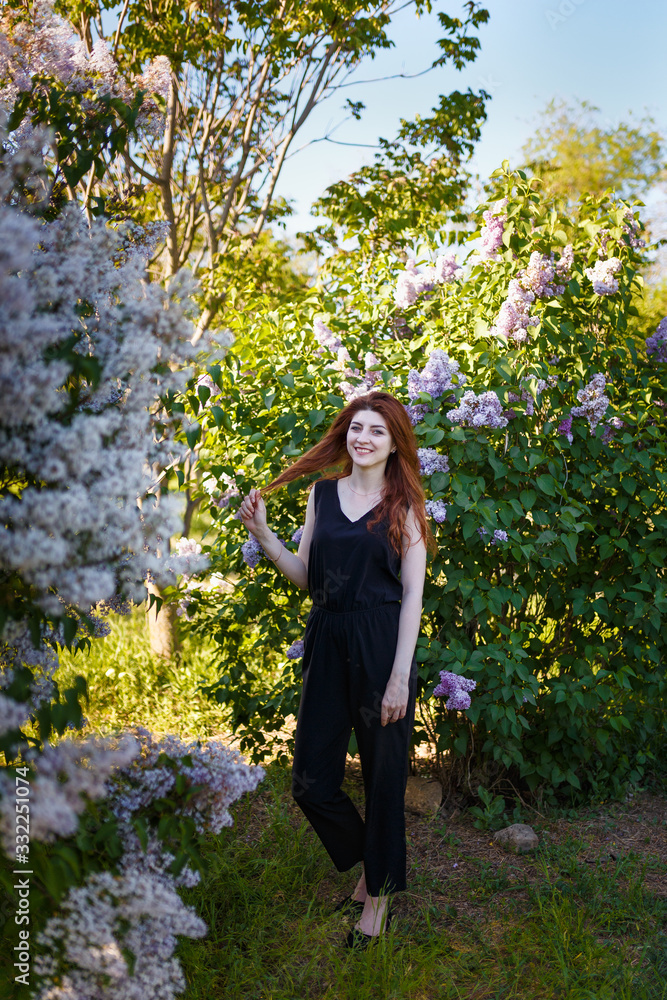 Portrait of young woman or girl among lilac blooming bushes Portrait of young woman or girl among lilac blooming bushes