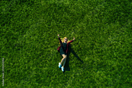 Happy woman relaxing on the grass. Aerial top view of vacation during sunny summer day