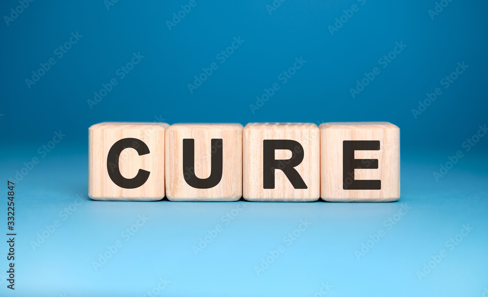CURE - text on wooden blocks, medical concept, blue background CURE - text on wooden blocks, medical concept, blue background