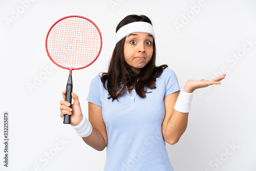 Young badminton player woman over isolated white background making doubts gesture © luismolinero