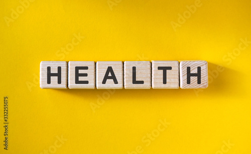 HEALTH - MEDICAL concept on a yellow background. Wooden cubes.