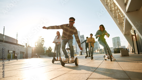 Let the life roll. A group of friends riding kick scooters and segways on a sunny day photo