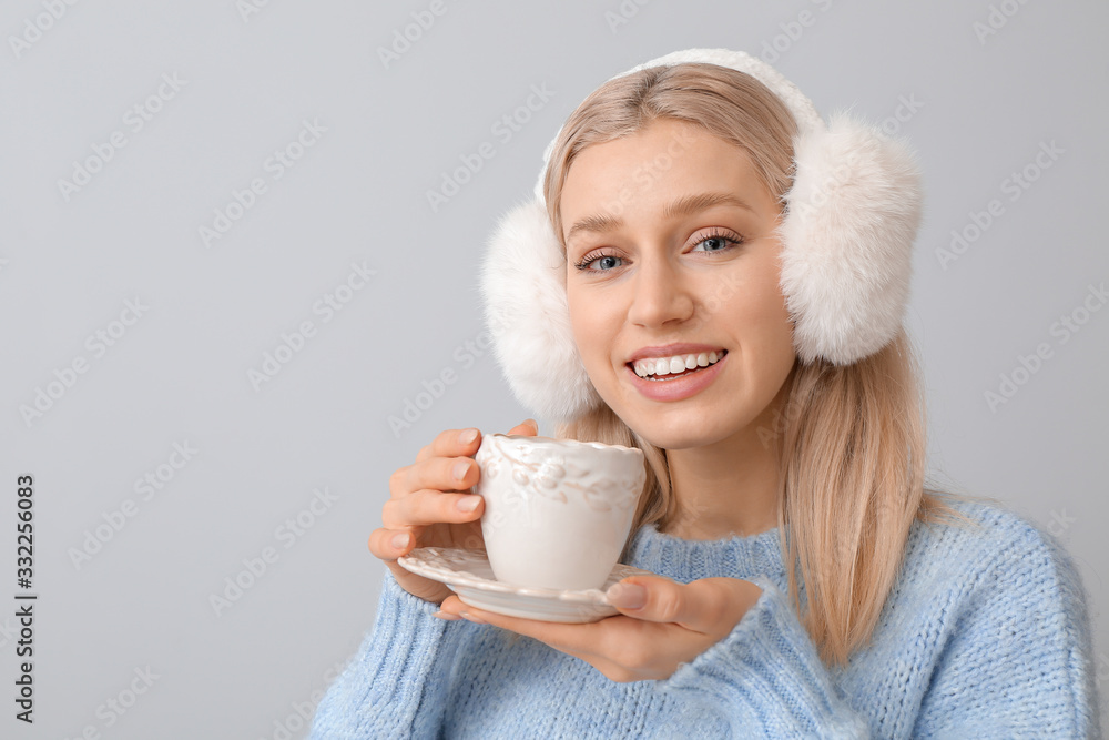 Beautiful young woman with cup of tea on grey background Beautiful young woman with cup of tea on grey background