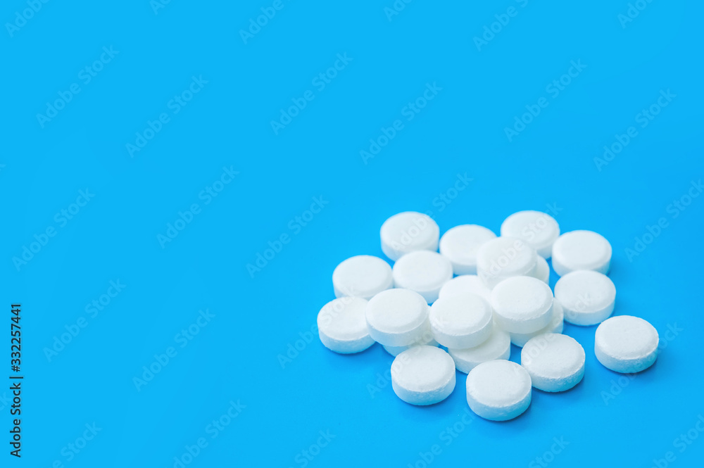 a bunch of white pills. a lot of medicine on a white background. pyramid, tower, slide on a blue background