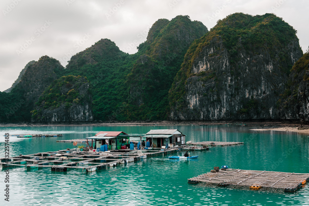Fototapeta premium Scenic view of rocks and local fishing boat in the Ha Long Bay of the South China Sea, Vietnam. The Ha Long Bay is a popular tourist destination of Asia.