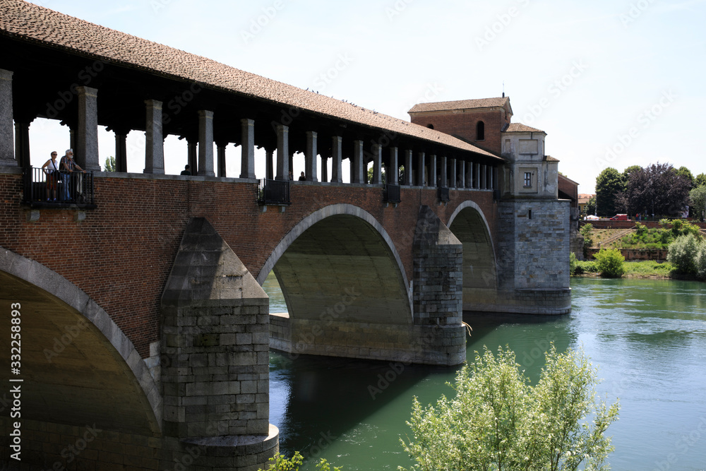 Naklejka premium Pavia (PV), Italy - June 09, 2018: The Ponte Coperto (covered bridge), also known as the Ponte Vecchio (old bridge), a brick and stone arch bridge over the Ticino River in Pavia, Lombardy, Italy