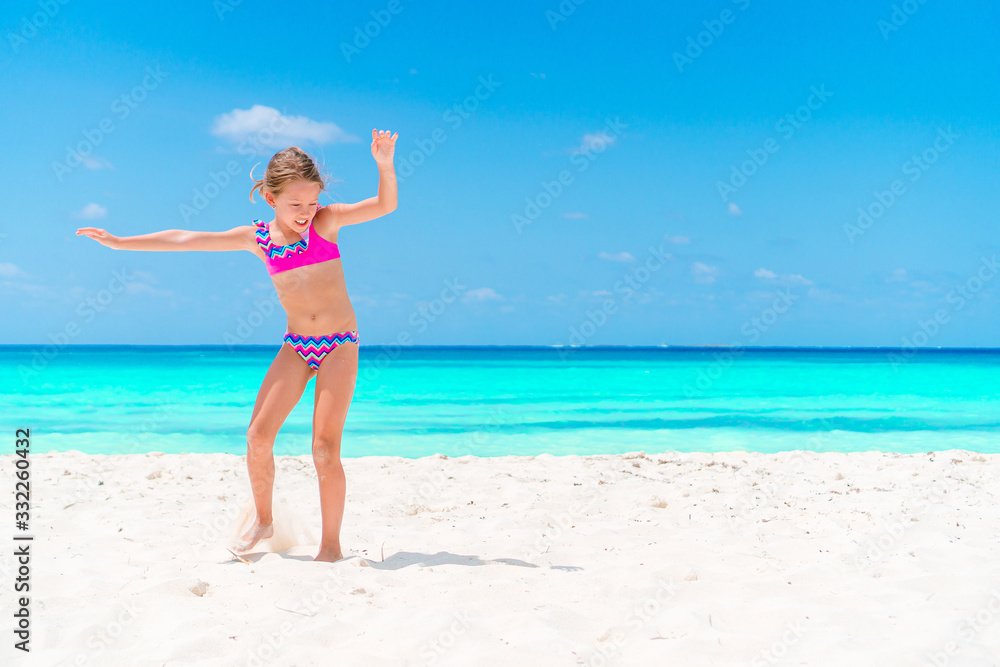 Adorable little girl have fun at tropical beach during vacation Adorable little girl have fun at tropical beach during vacation