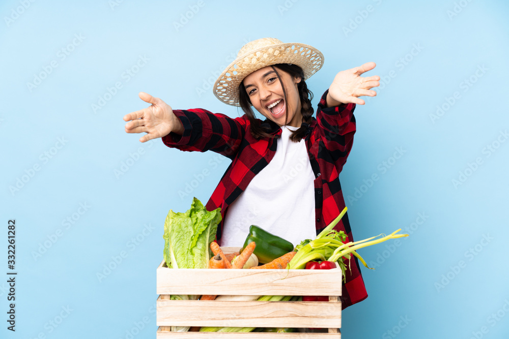 Young farmer Woman holding fresh vegetables in a wooden basket presenting and inviting to come with hand