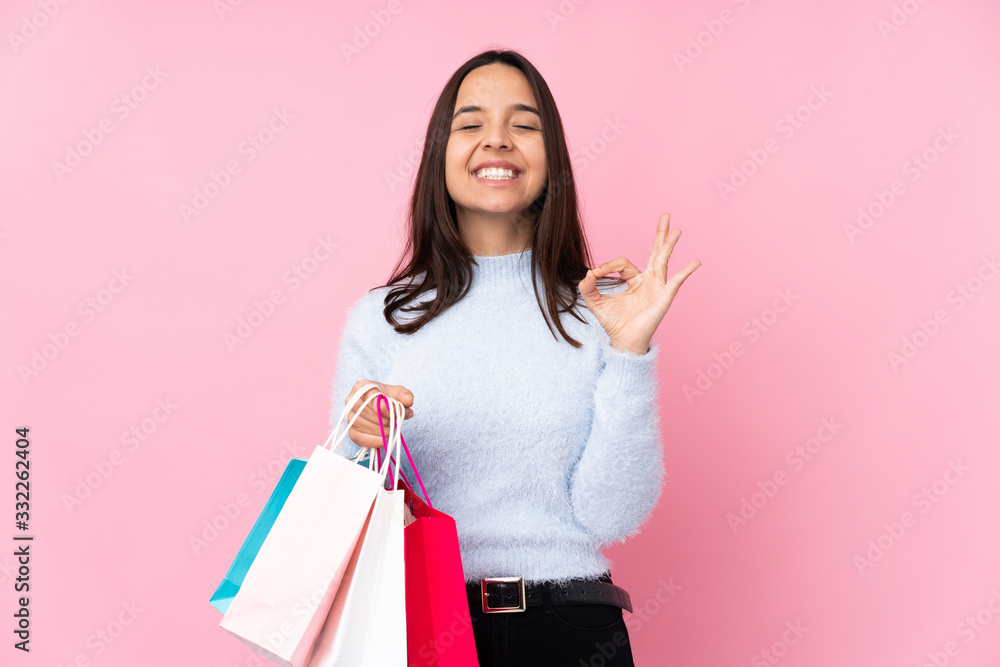 Young woman with shopping bag over isolated pink background in zen pose Young woman with shopping bag over isolated pink background in zen pose