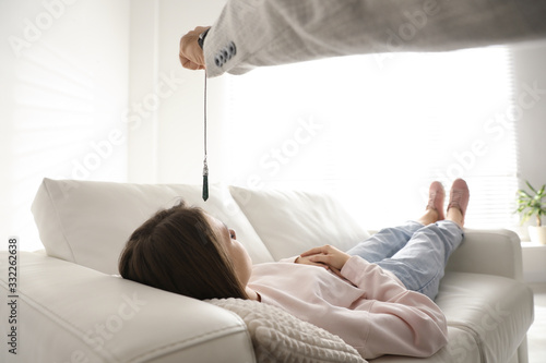 Psychotherapist using pendulum during hypnotherapy   session in office photo