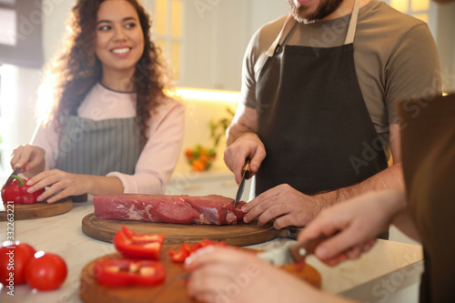 People cooking food together in kitchen, closeup