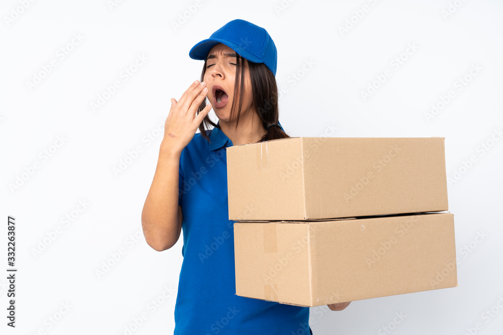 Young delivery brunette girl over isolated white background yawning and covering wide open mouth with hand Young delivery brunette girl over isolated white background yawning and covering wide open mouth with hand