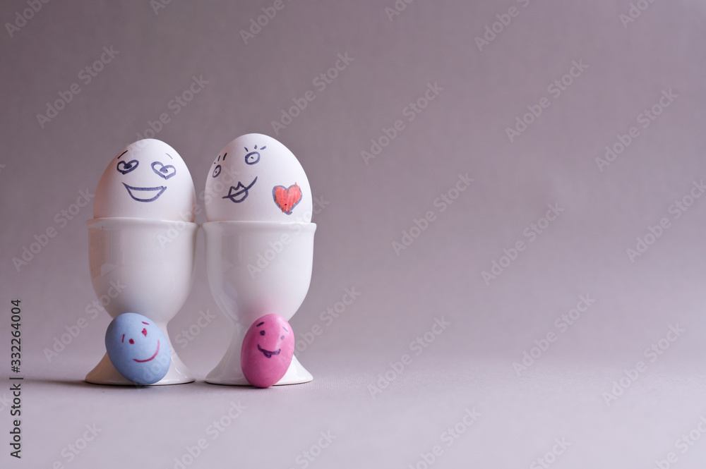 Eggs with a face. Mom, dad and a lot of little colored kids eggs. The Creative idea for decorating Easter Sunday. Copy space . Minimalism Eggs with a face. Mom, dad and a lot of little colored kids eggs. The Creative idea for decorating Easter Sunday. Copy space . Minimalism