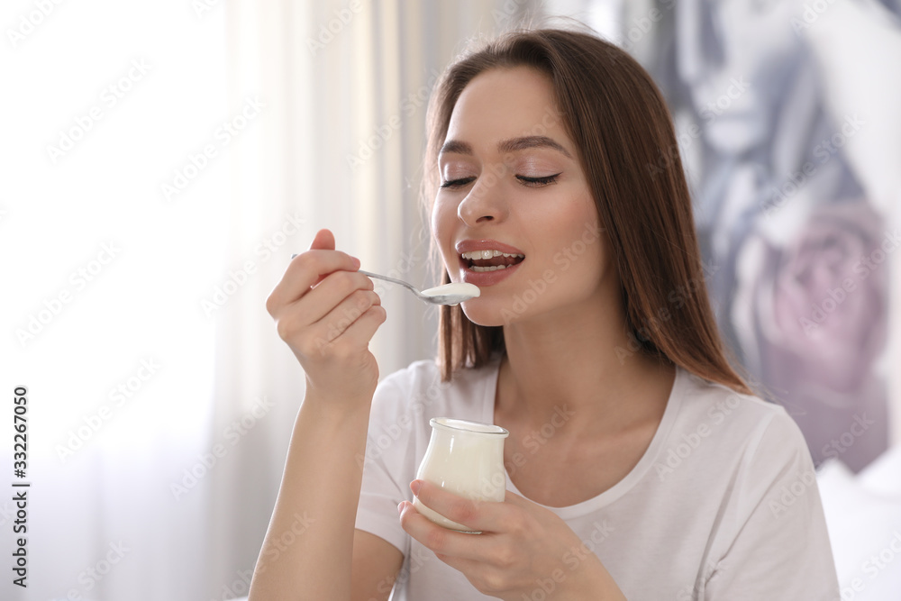 Young attractive woman eating tasty yogurt at home Young attractive woman eating tasty yogurt at home