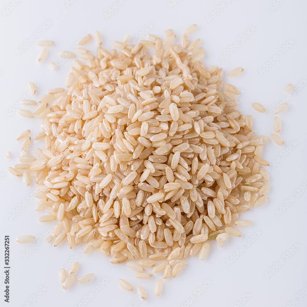 raw brown rice on white acrylic background raw brown rice on white acrylic background