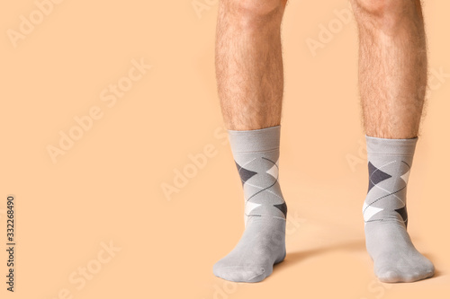 Male legs in socks on color background © Pixel-Shot