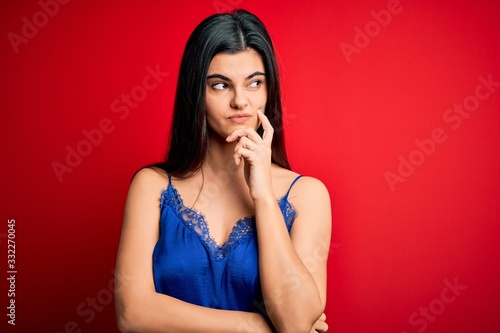 Young beautiful brunette woman wearing elegant and comfortable lingerie underwear with hand on chin thinking about question, pensive expression. Smiling with thoughtful face. Doubt concept. © Krakenimages.com