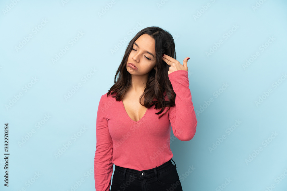 Young mixed race woman isolated on blue background with problems making suicide gesture Young mixed race woman isolated on blue background with problems making suicide gesture