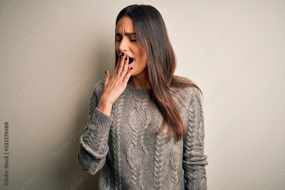 Young beautiful brunette woman wearing casual sweater over isolated white background bored yawning tired covering mouth with hand. Restless and sleepiness. Young beautiful brunette woman wearing casual sweater over isolated white background bored yawning tired covering mouth with hand. Restless and sleepiness.