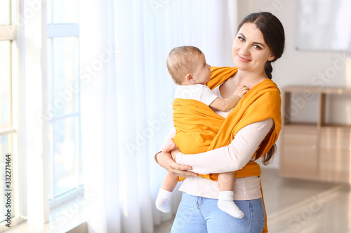 Smiling young mother carryi...