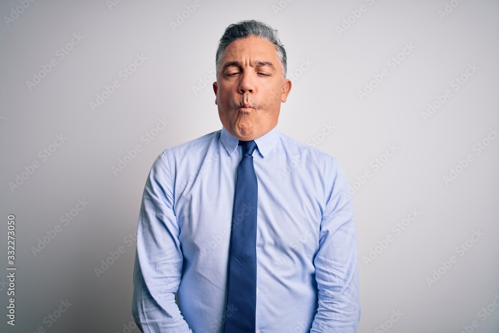 Middle age handsome grey-haired business man wearing elegant shirt and tie making fish face with lips, crazy and comical gesture. Funny expression. Middle age handsome grey-haired business man wearing elegant shirt and tie making fish face with lips, crazy and comical gesture. Funny expression.