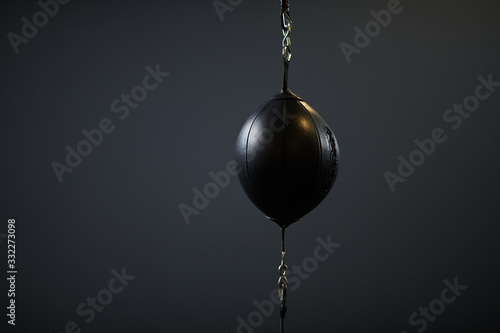 Background image of chained punching bag on black background in fight training center or gym, copy space