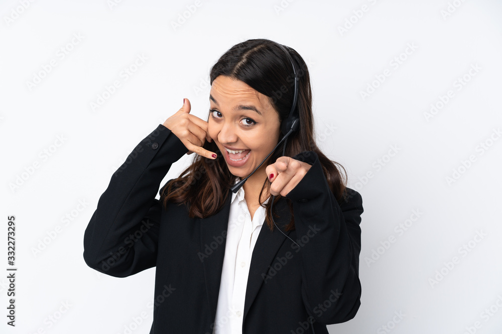 Young telemarketer woman isolated on white background making phone gesture and pointing front Young telemarketer woman isolated on white background making phone gesture and pointing front