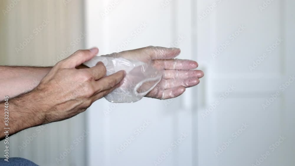 Male hands taking off his medical latex gloves at home, Coronavirus protection concept. Male hands taking off his medical latex gloves at home, Coronavirus protection concept.