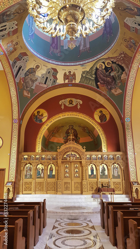 Aisle, stage and ornate celing with chandelier of a Greek Orthodox church