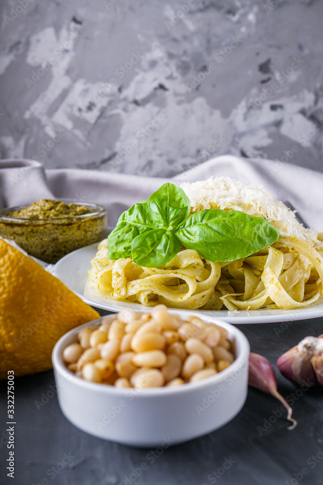 Delicious tagliatelle pasta with pesnto sauce on dark stone background