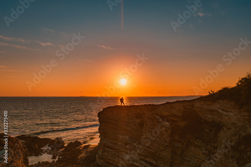 Beautiful sunset with a man standing at the risk